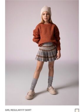 High-waisted, A-line silhouette with classic pleats.